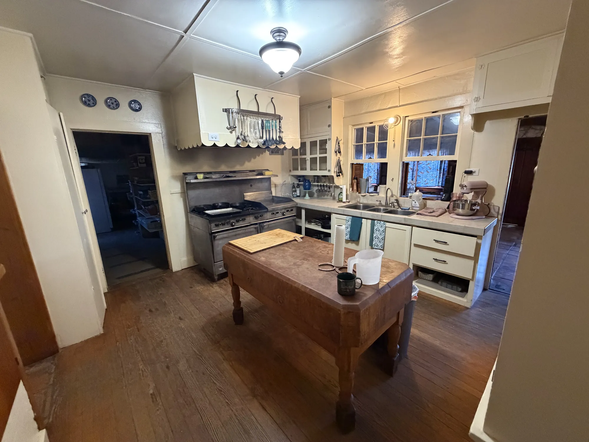 The lodge kitchen: a butcher-block island in front of a commercial range, with the sink under the windows